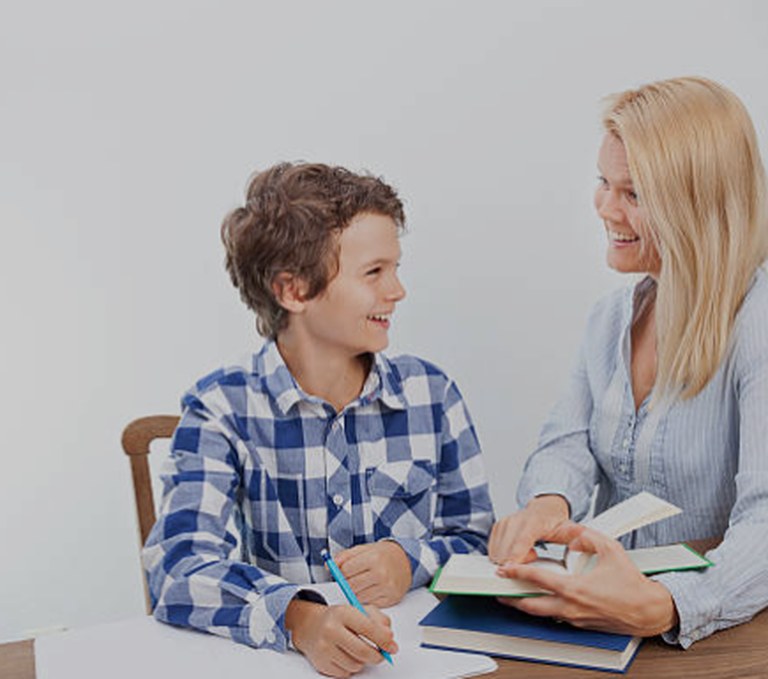 Smiling tutor helping a student at a desk
